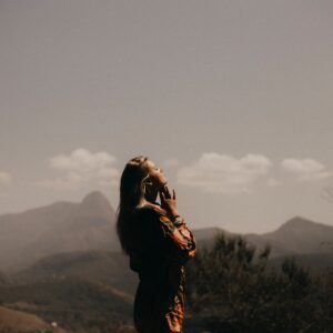woman in prayer in front of smoky mountains