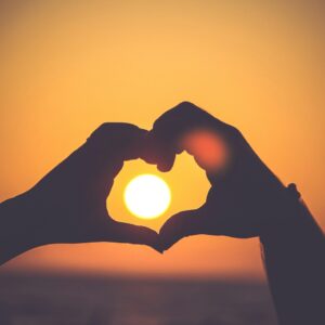 silhouette of person's hands forming heart